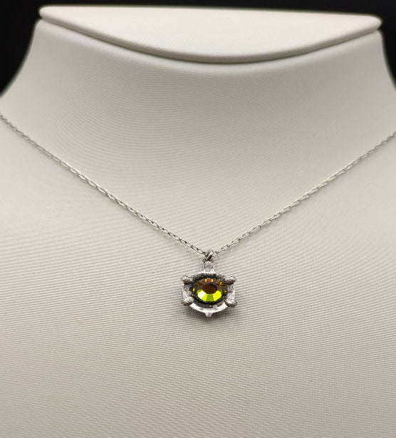 Necklace with a pendant on a mannequin bust against a black background