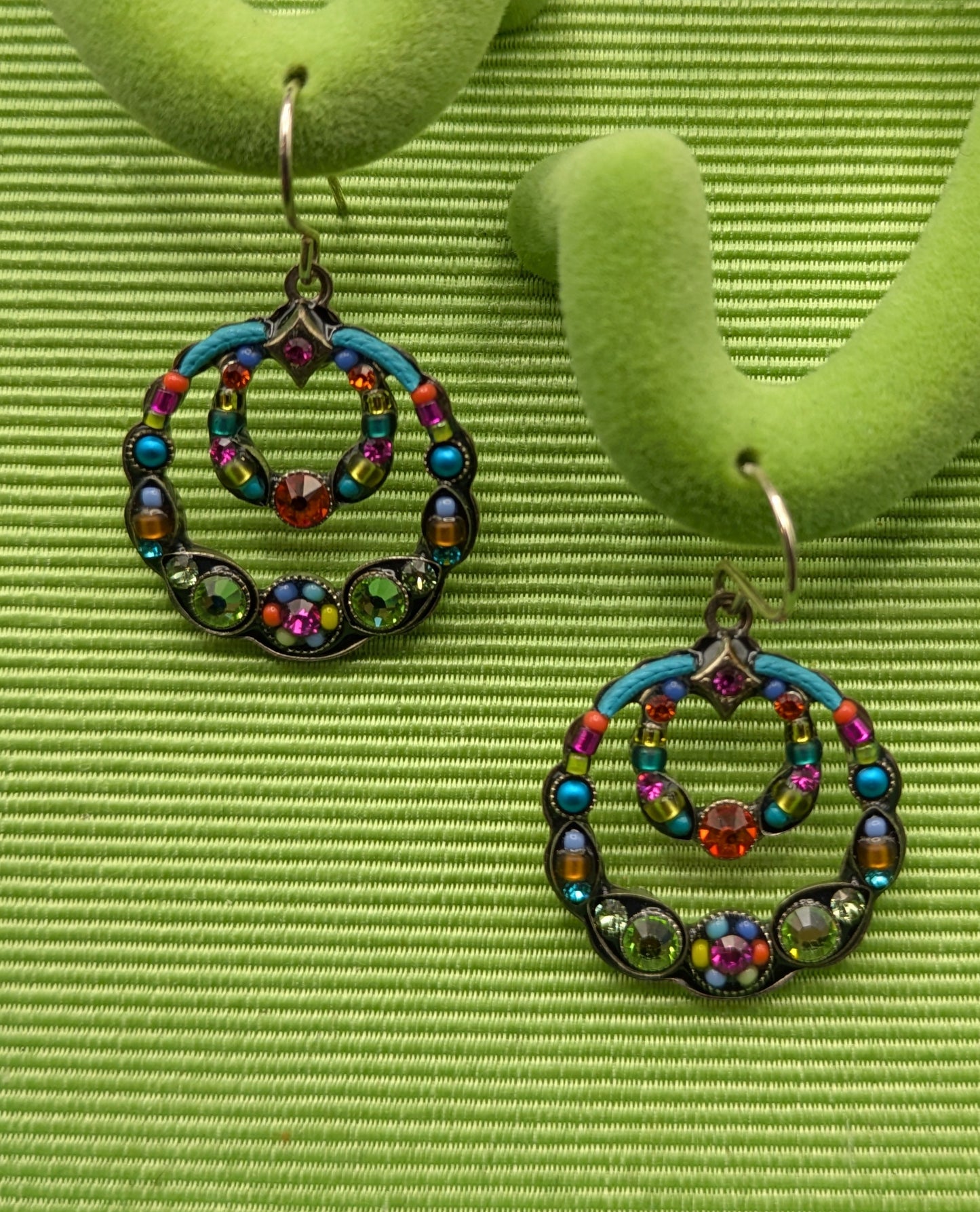 Colorful beaded earrings on a green earring stand