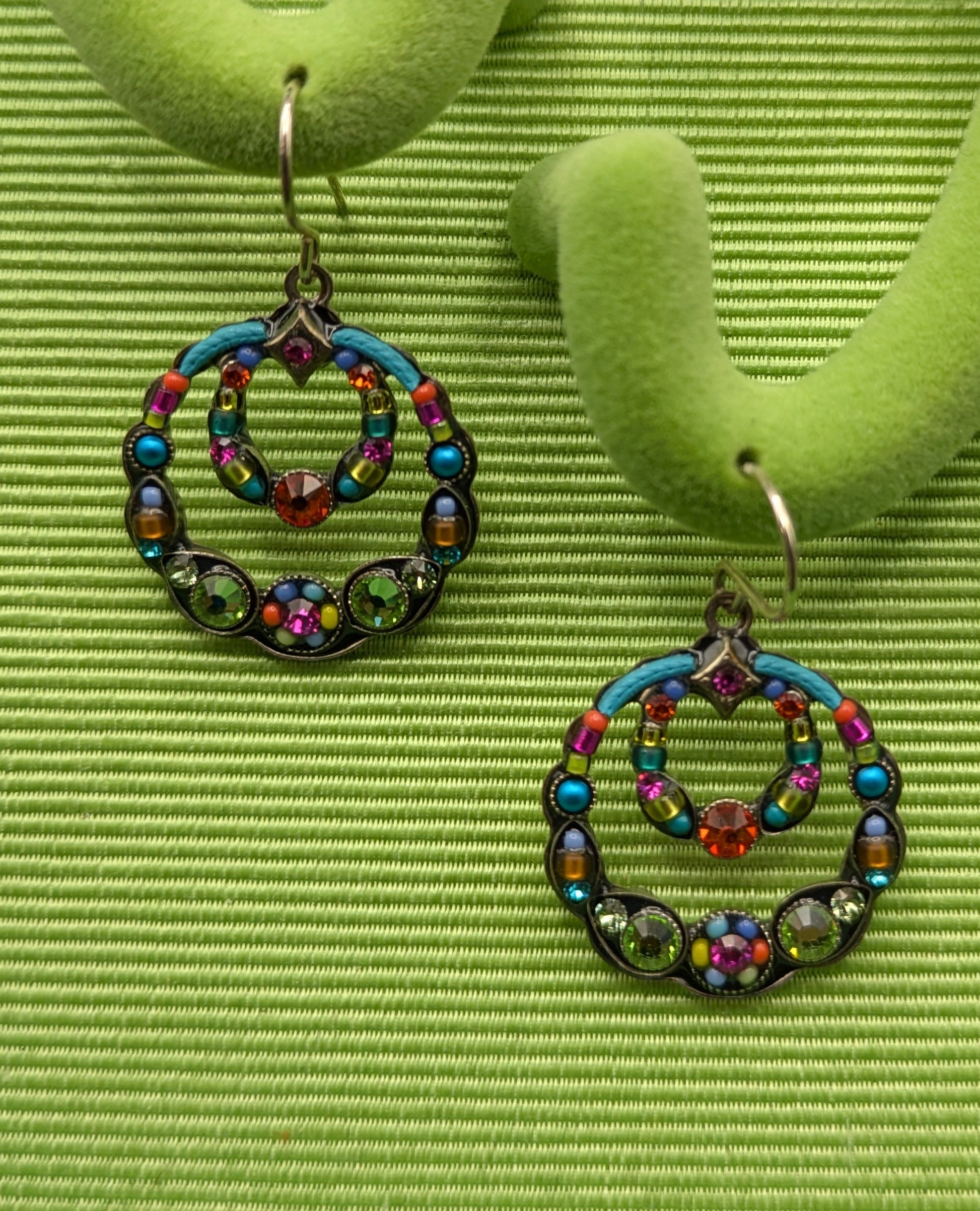 Colorful beaded earrings on a green earring stand