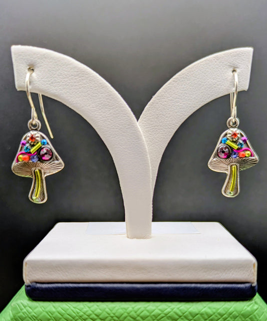Mushroom-shaped earrings on a white stand with a green base