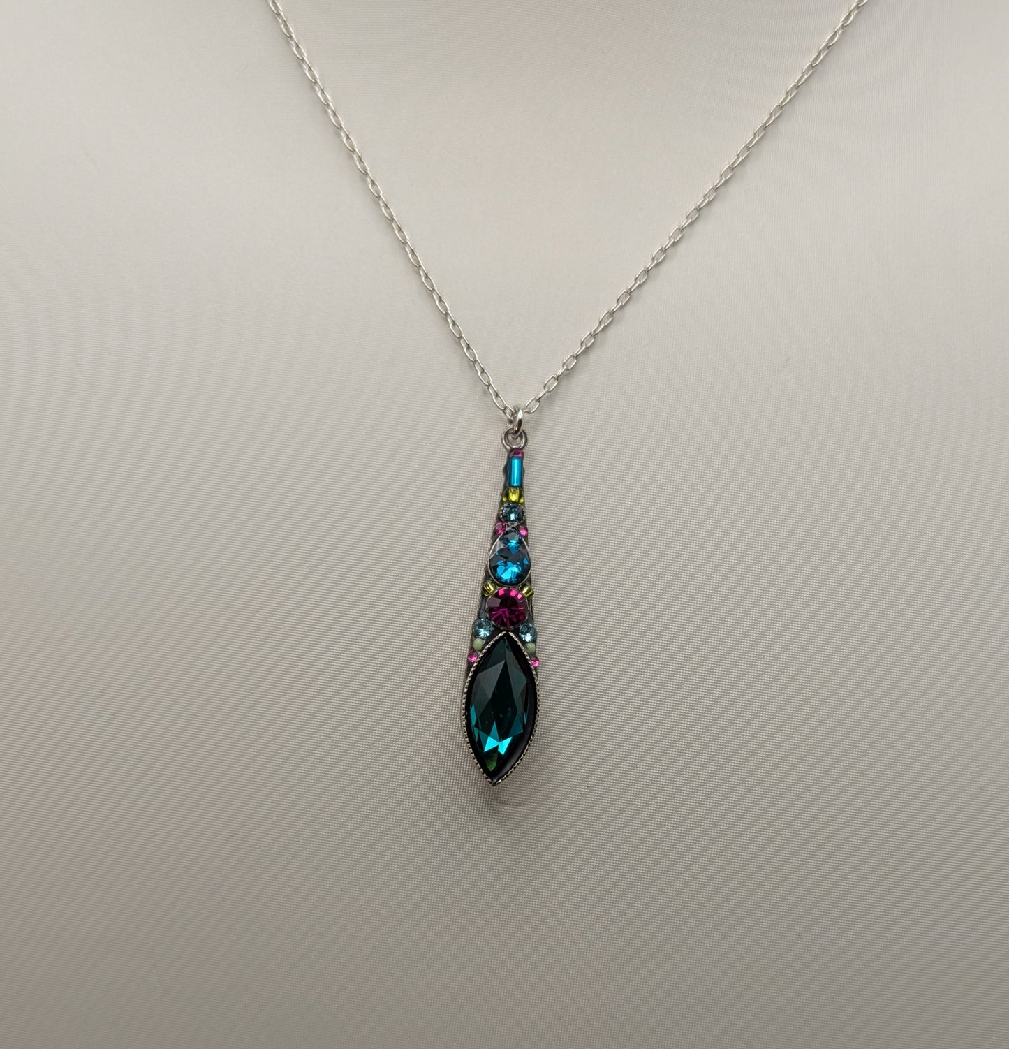 Teardrop-shaped pendant necklace on a mannequin with a plain background