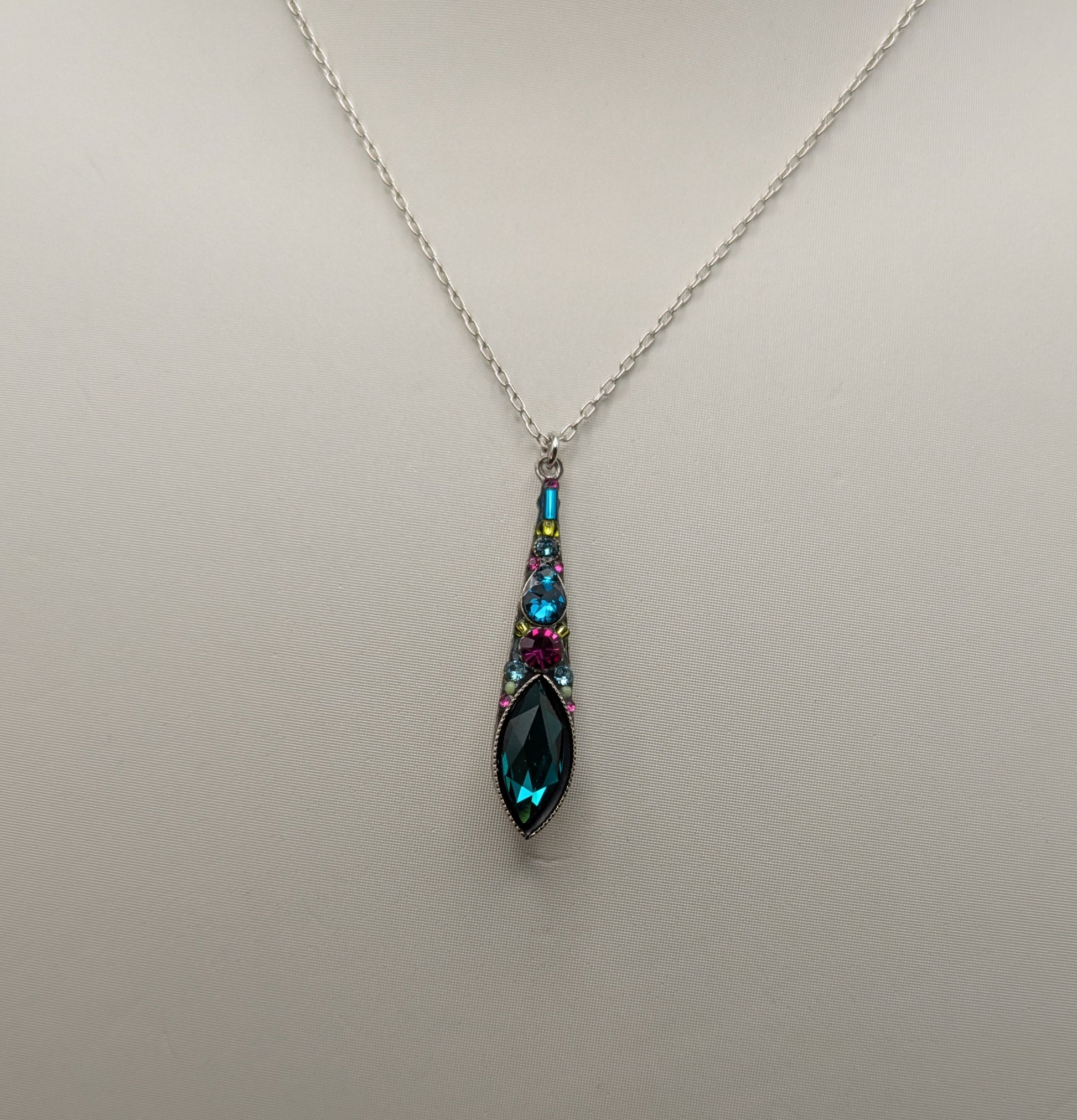 Teardrop-shaped pendant necklace on a mannequin with a plain background
