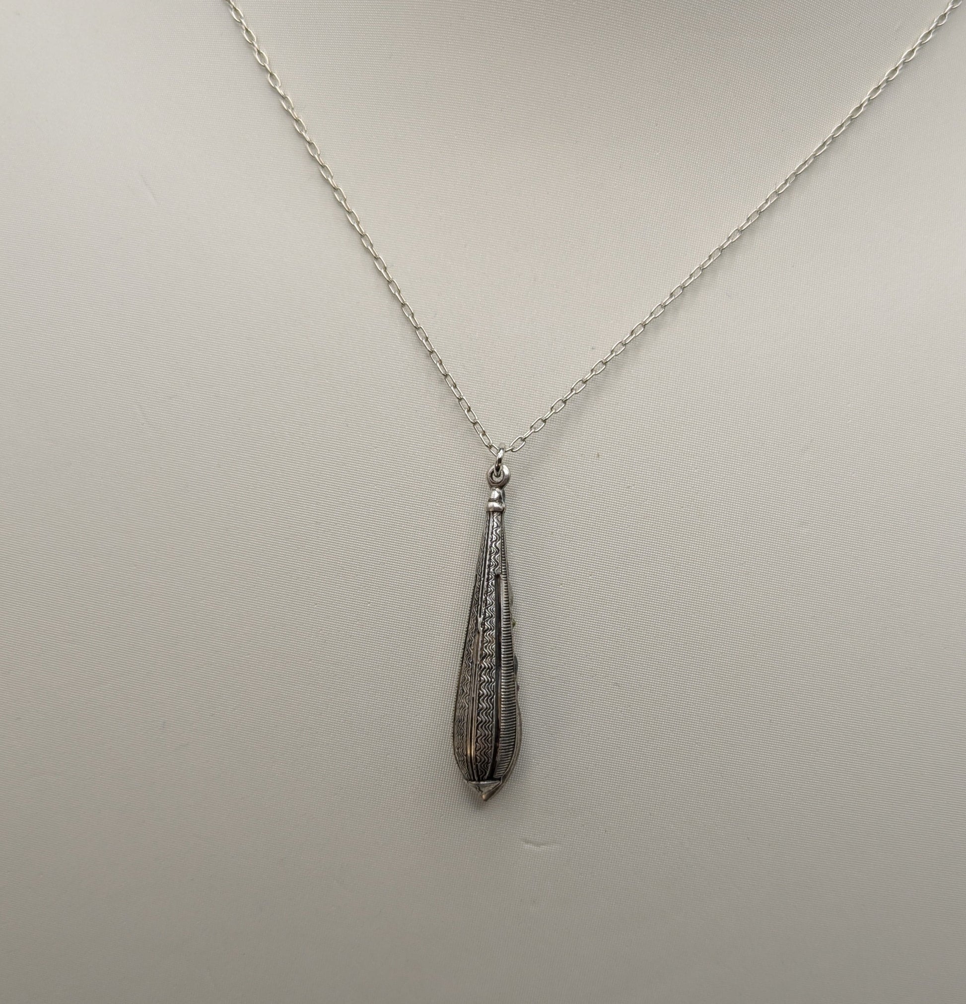 Necklace with a teardrop-shaped pendant on a mannequin bust.