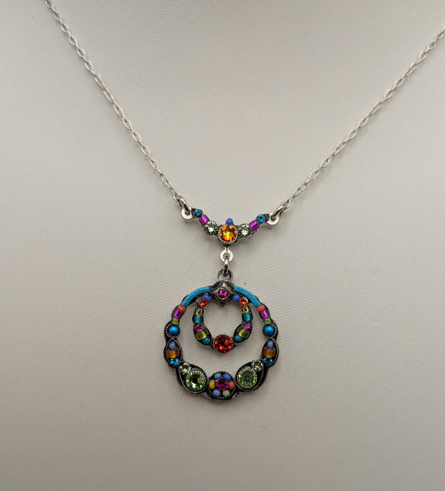 Necklace with a colorful pendant on a light gray background