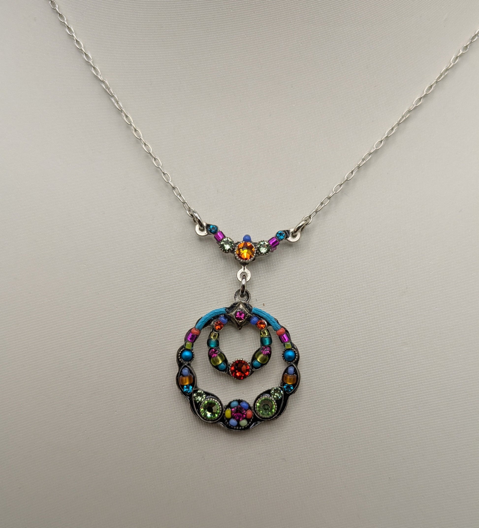 Necklace with a colorful pendant on a light gray background