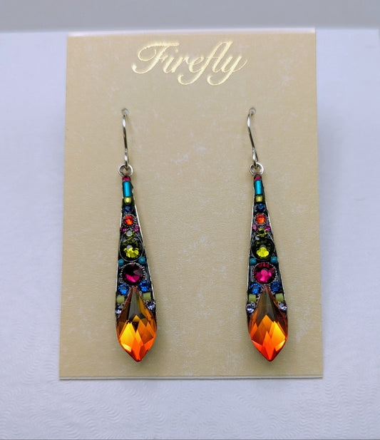 A pair of Firefly brand teardrop-shaped dangling earrings with colorful rhinestones and a bright orange flame-shaped crystal at the bottom, displayed on a beige card inside a white box.