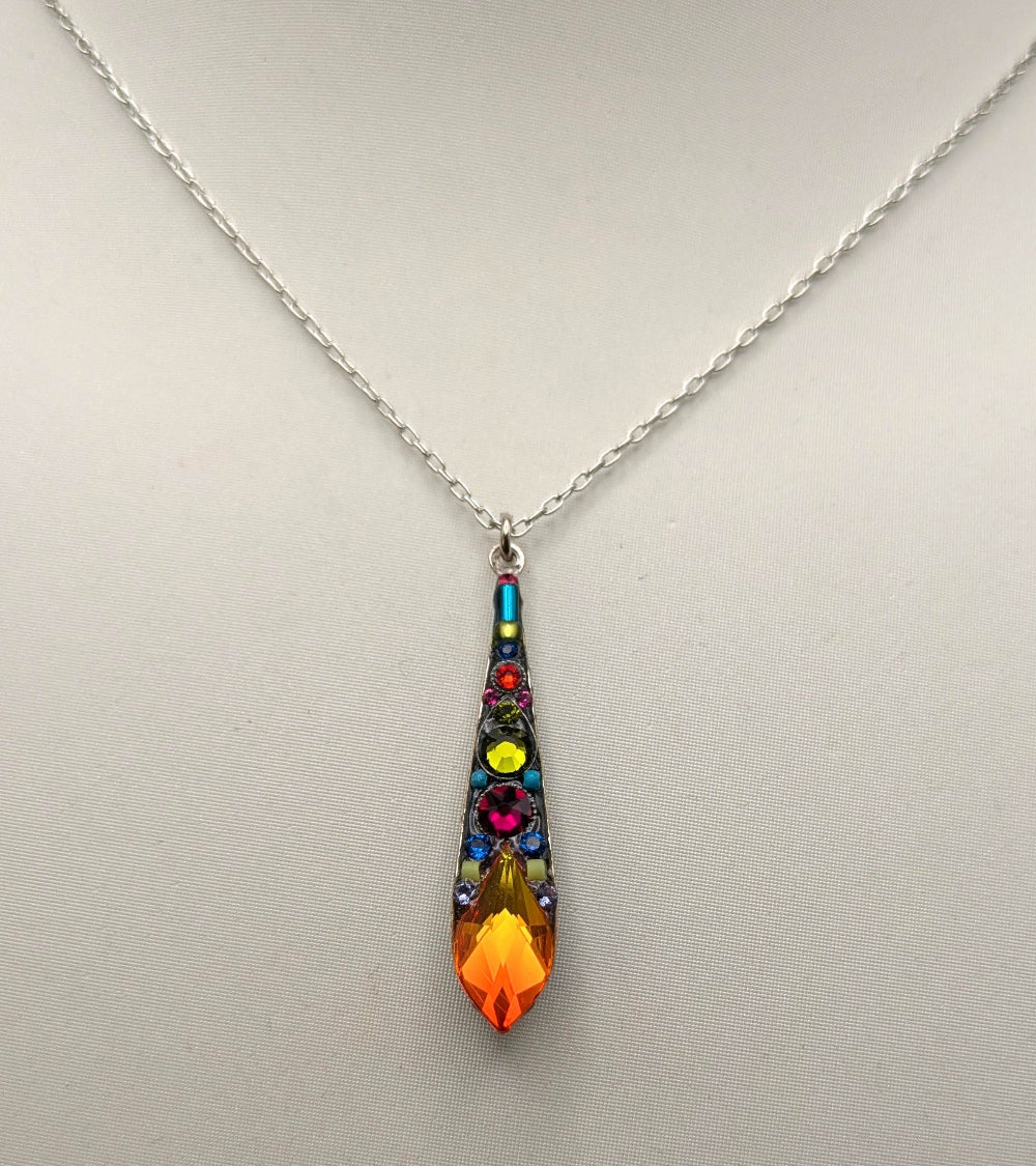 A silver chain necklace with a teardrop-shaped pendant featuring a colorful mosaic design and a bright orange crystal at the bottom, displayed on a white mannequin bust.