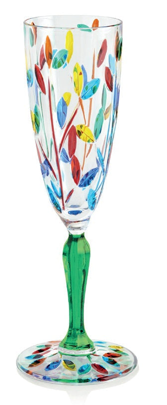 A multicolored hand-painted wine glass with a leaf pattern and a green stem.