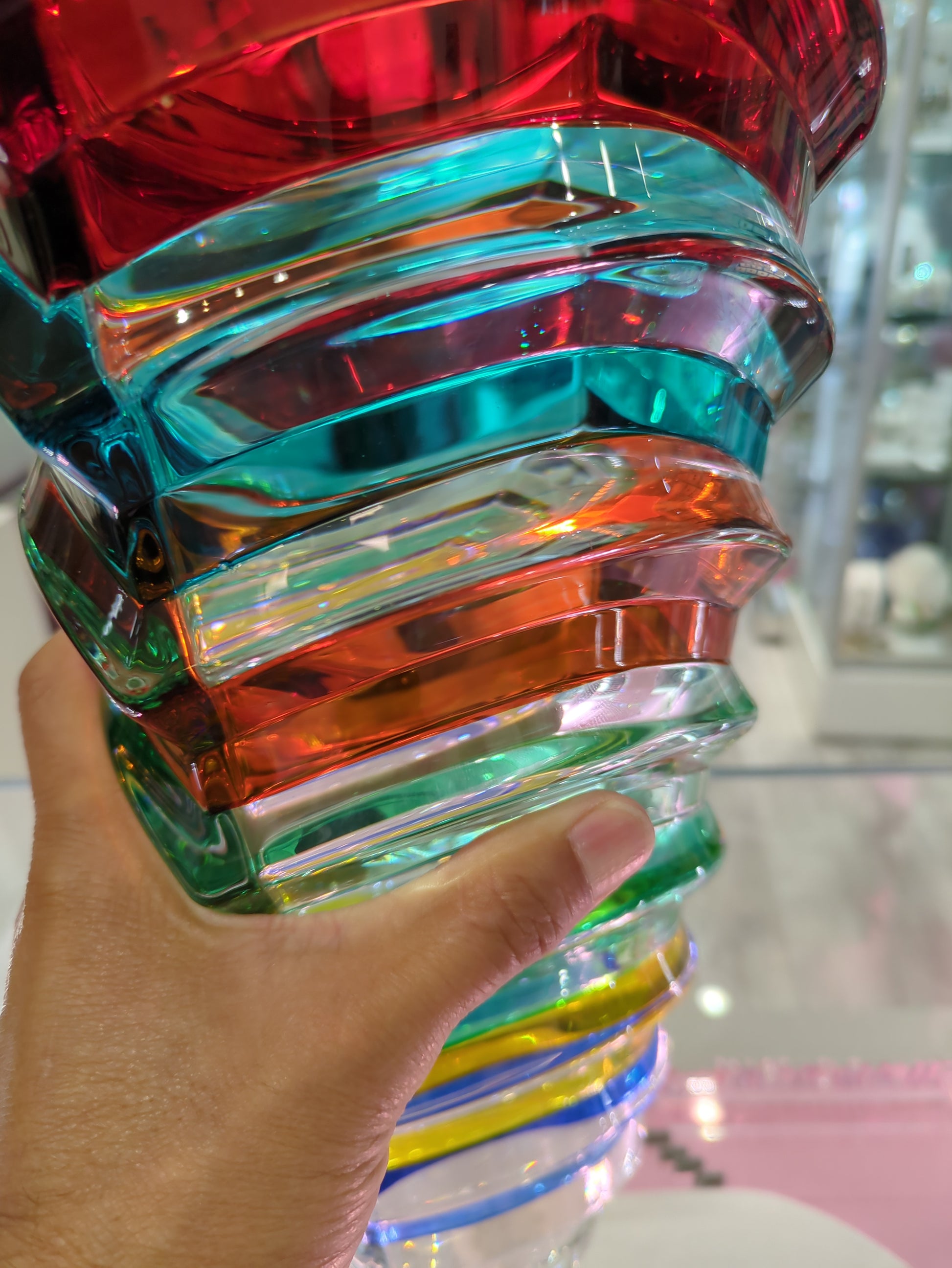 Hand holding a colorful transparent bracelet with a blurred background