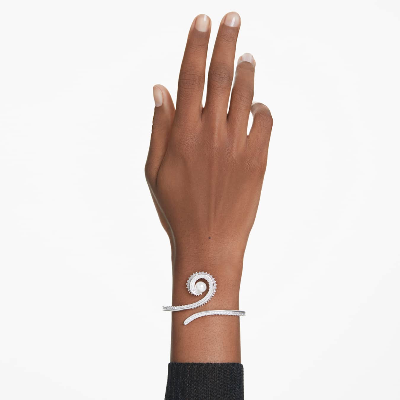 Hand wearing a silver bracelet with a white background