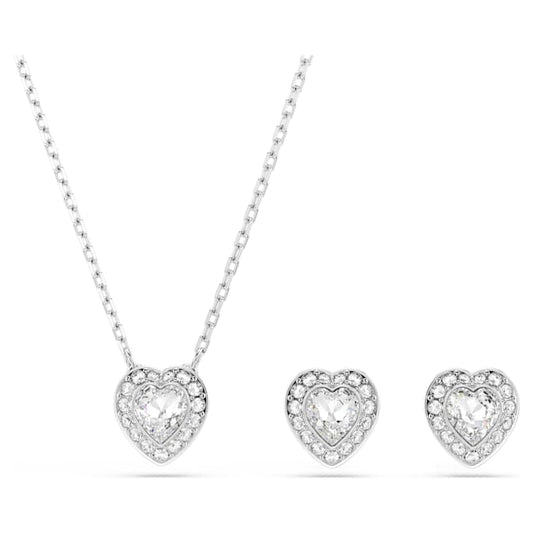 A rhodium-plated jewelry set featuring a heart-shaped pendant necklace and a pair of heart-shaped stud earrings, both adorned with clear crystals.