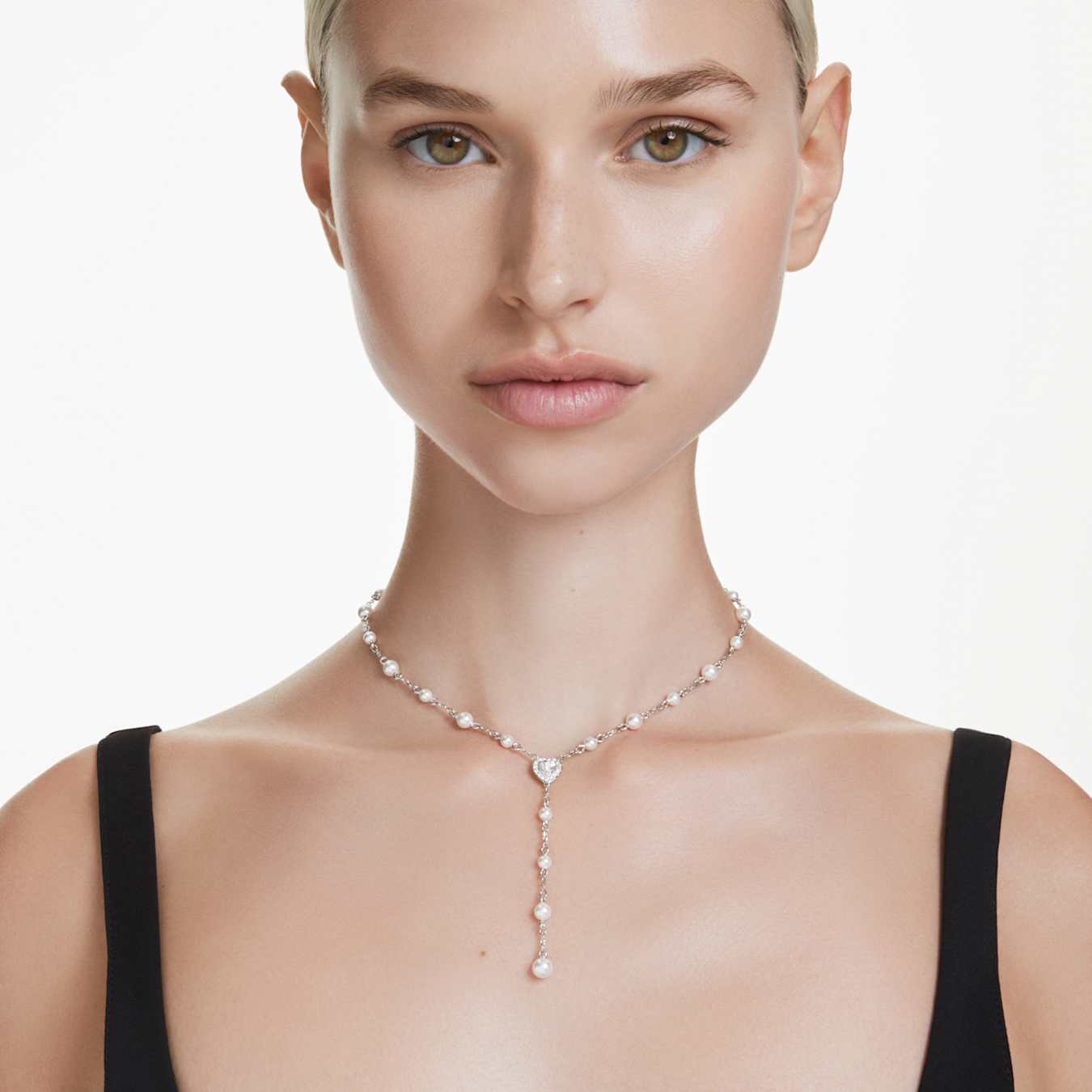 A woman wearing a rhodium plated Y-necklace with mixed cuts of Swarovski crystals and a crystal pearl hanging from the chain.
