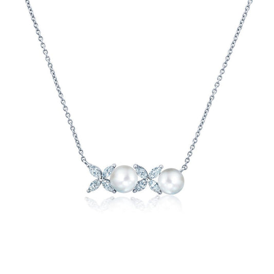 A white pearl necklace with a silver chain and a series of cubic zirconia embellishments.