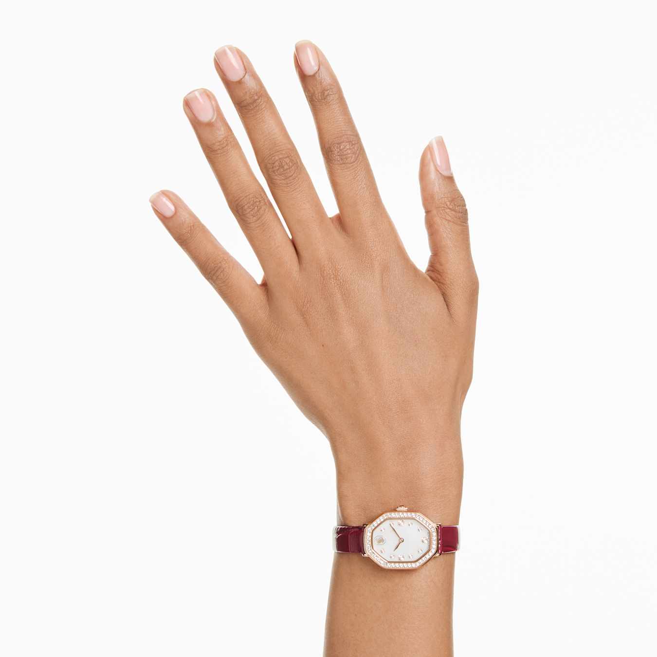 Hand wearing a watch with a white face and red strap on a white background