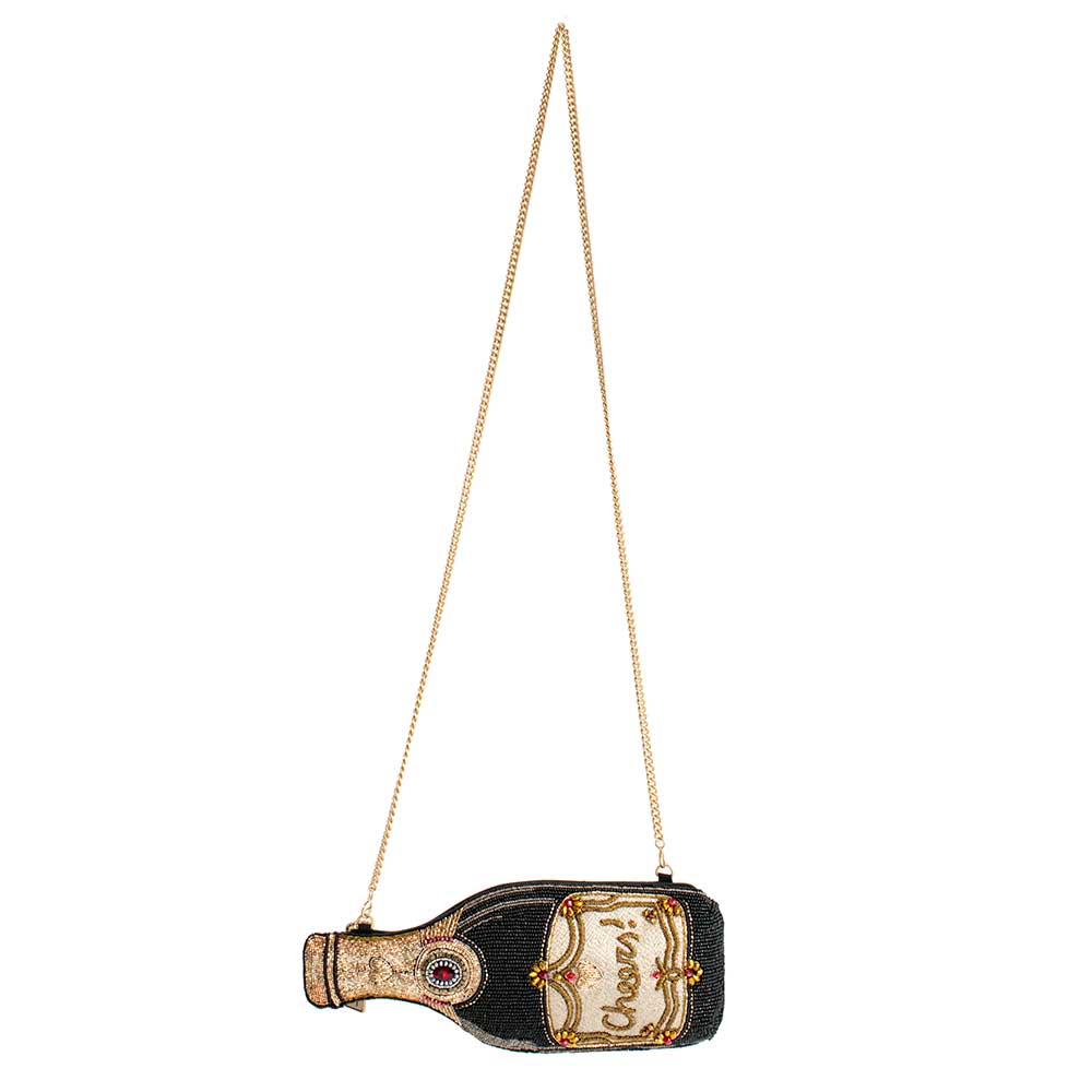 A beaded handbag designed to resemble a champagne bottle with long chain strap.