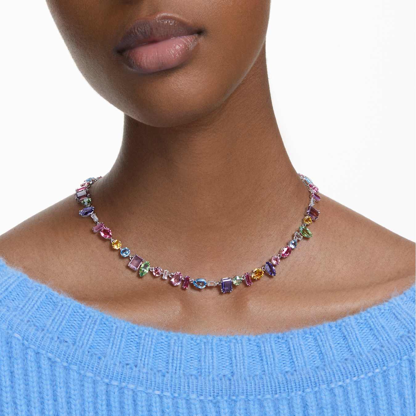 Multicolored gemstone necklace on a model wearing a blue sweater
