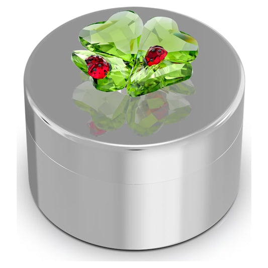 A glossy steel decorative box with a nature-inspired motif of a clover and ladybug, featuring green and red crystal figures on top.