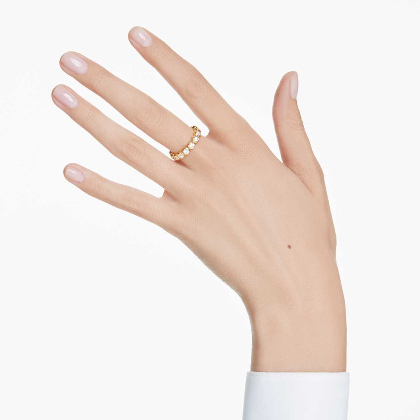 Hand wearing a gold ring on a white background