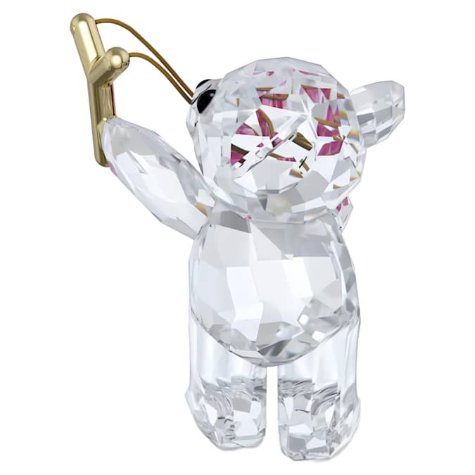 A crystal figurine of a bear with a pink heart and a gold-tone metal slingshot on white background.