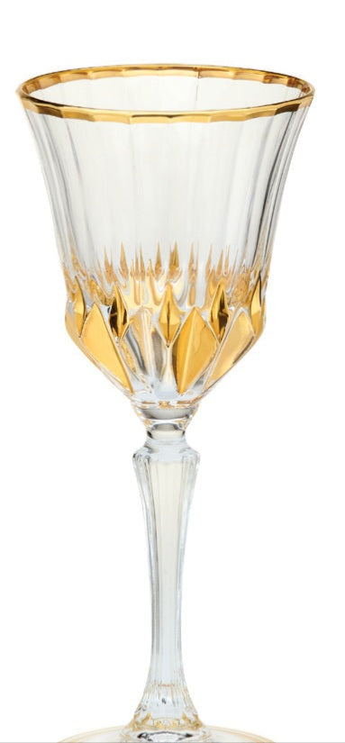 A clear wine glass with a gold rim and rainbow swirl pattern.