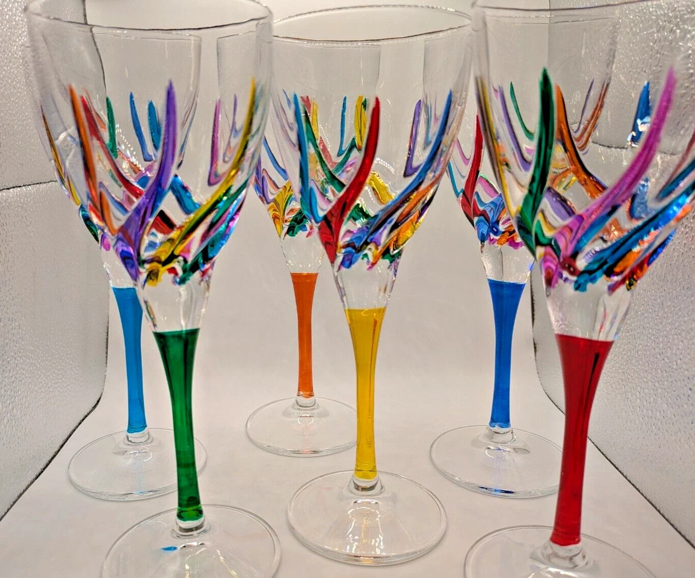 Set of colorful wine glasses with abstract designs on a white background