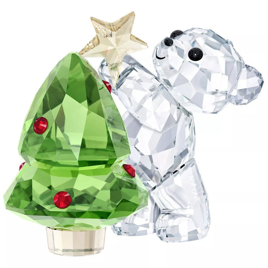 A Swarovski crystal figurine of a bear with a Christmas tree ornament.