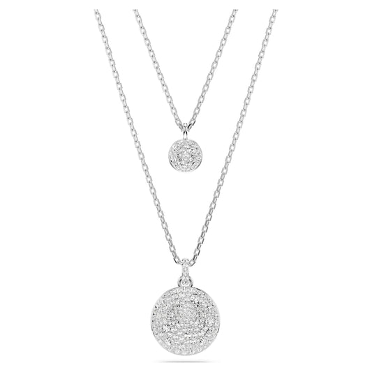 A layered pendant necklace with the top layer featuring a small circular pendant and the bottom layer showcasing a larger, intricate circular pendant, both in silver tone.