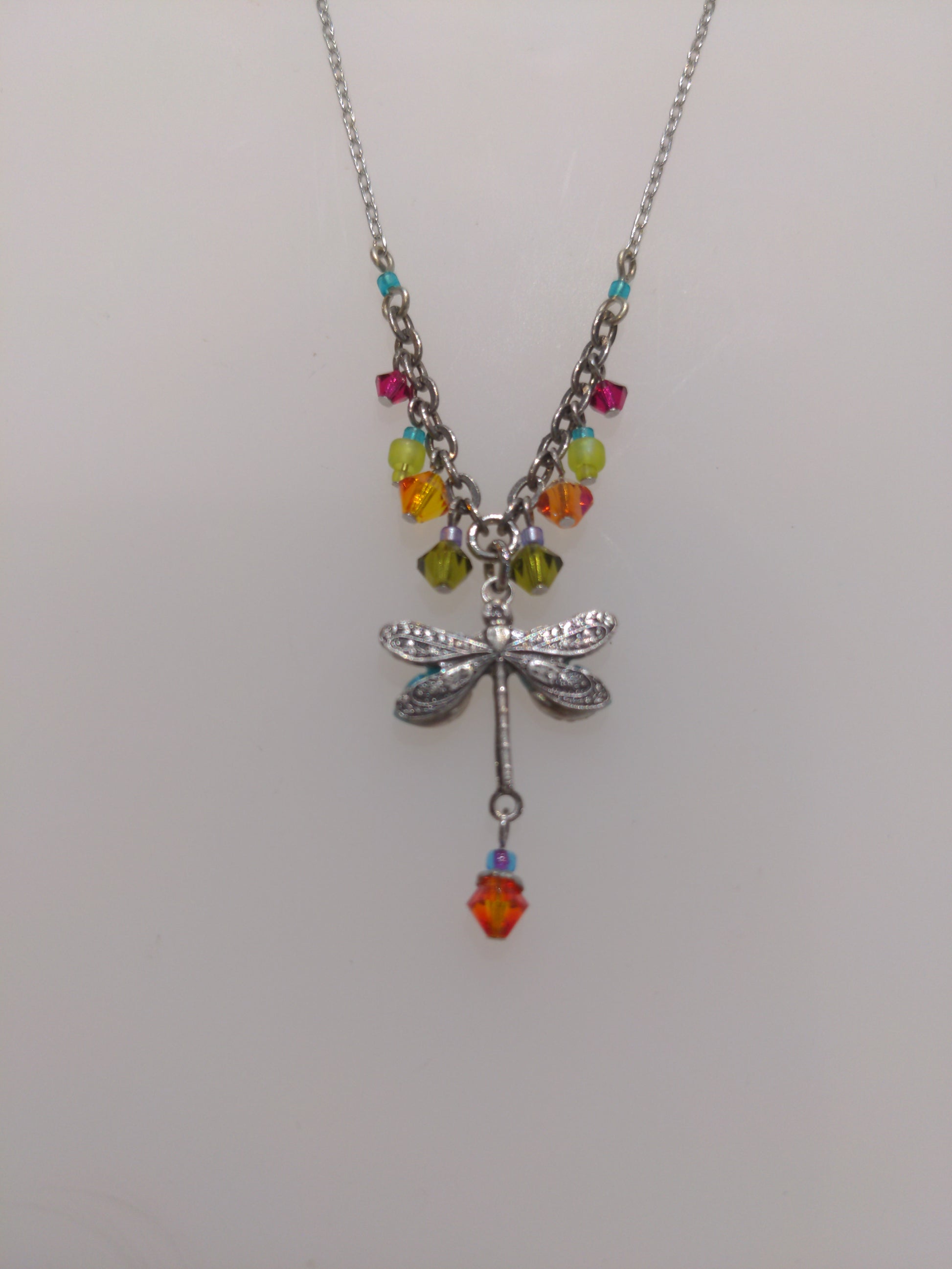 A back view of multicolored Firefly brand necklace featuring a dragonfly design