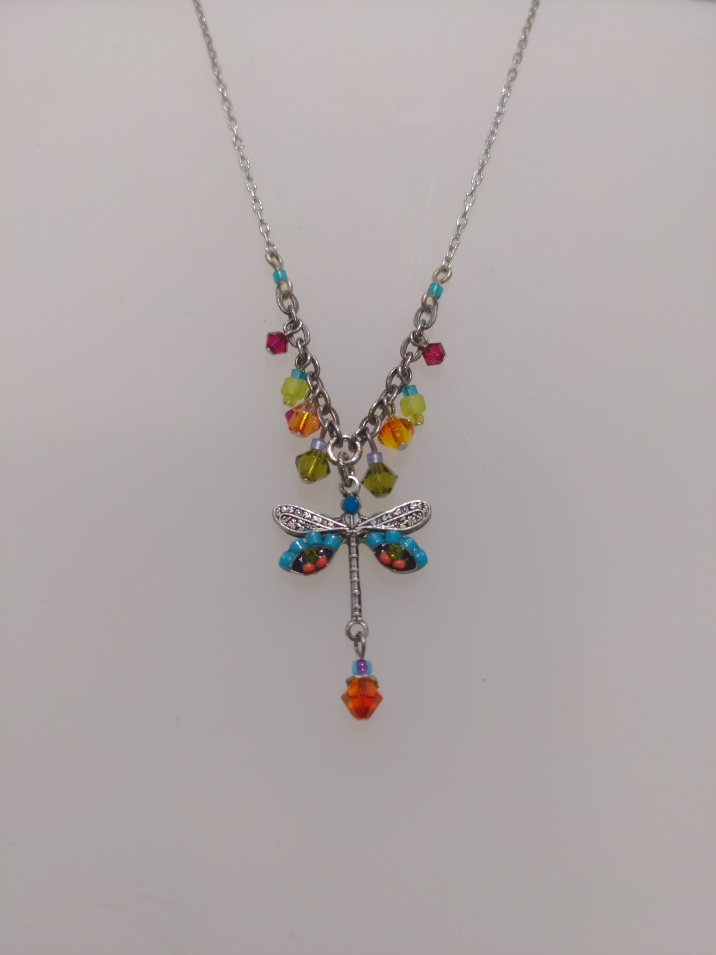 A multicolored Firefly brand necklace featuring a dragonfly design with intricate embellishments and a chain link.
