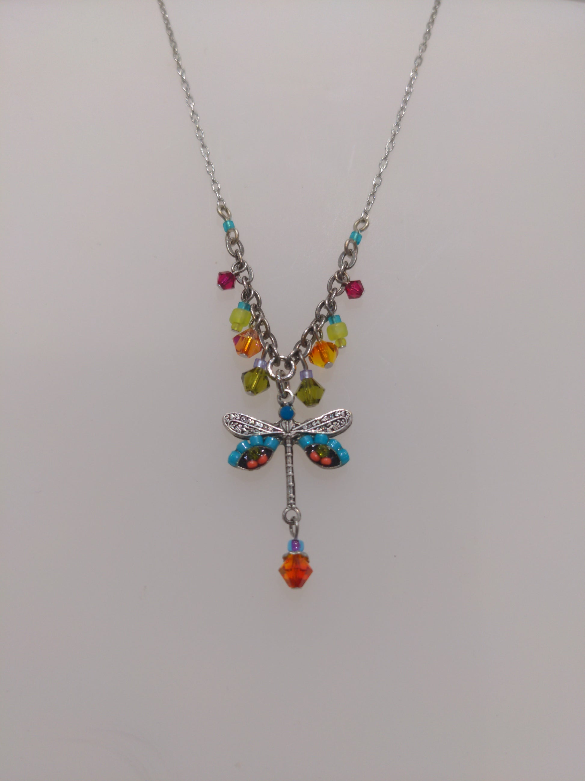 A multicolored Firefly brand necklace featuring a dragonfly design with intricate embellishments and a chain link.