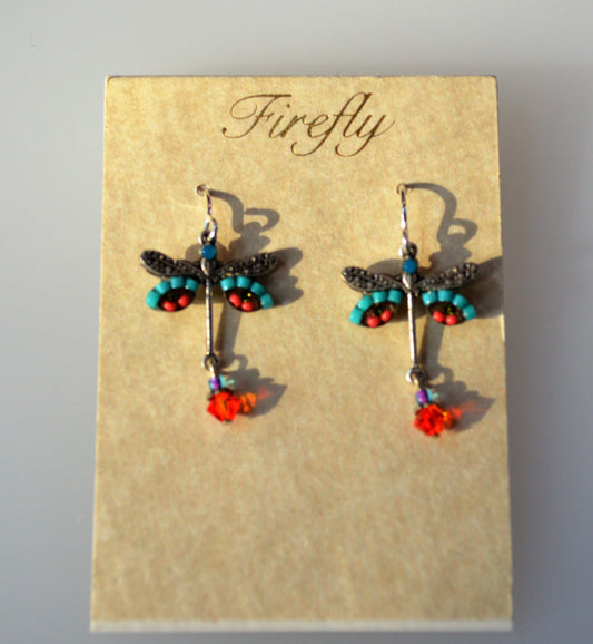 A pair of Firefly Jewelry dragonfly earrings with blue, orange, and turquoise colors, displayed on a card.
