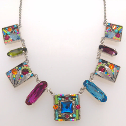 A multicolored Firefly jewelry necklace featuring a series of square and rectangular charms with colorful crystals, and a lobster claw clasp.
