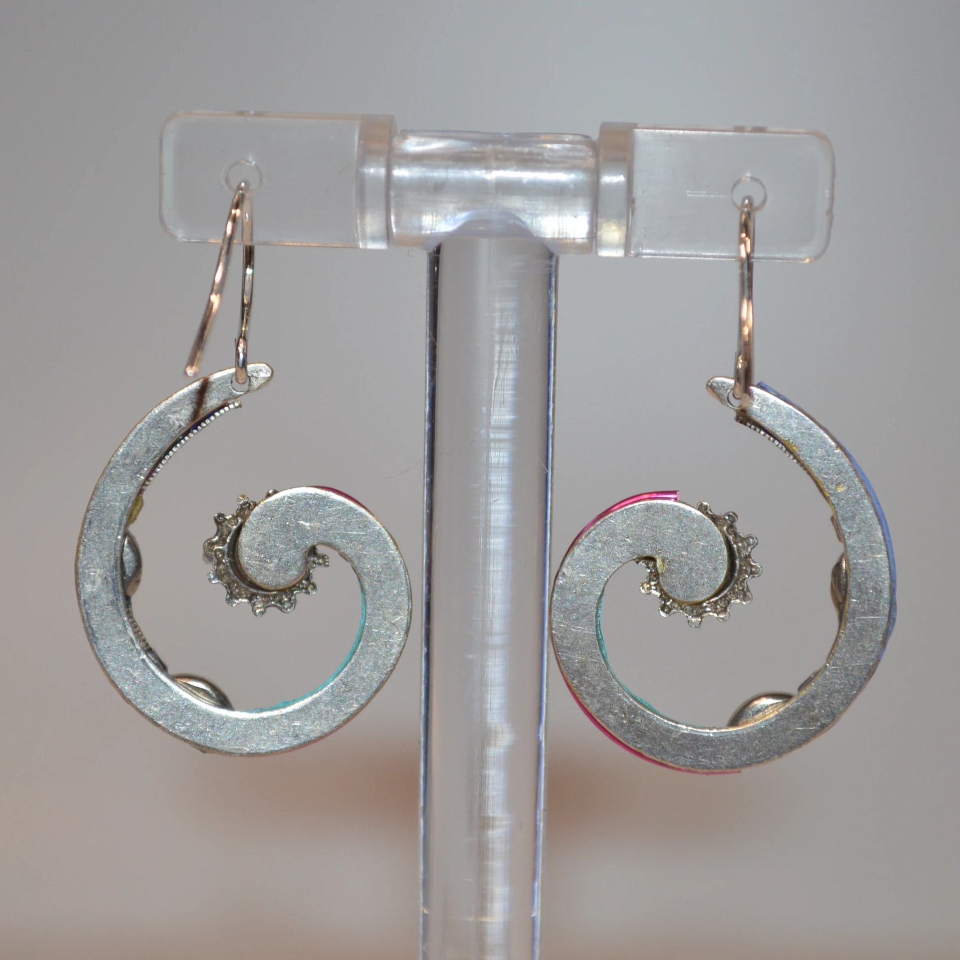 A pair of Firefly Jewelry earrings back view , displayed on a clear stand.