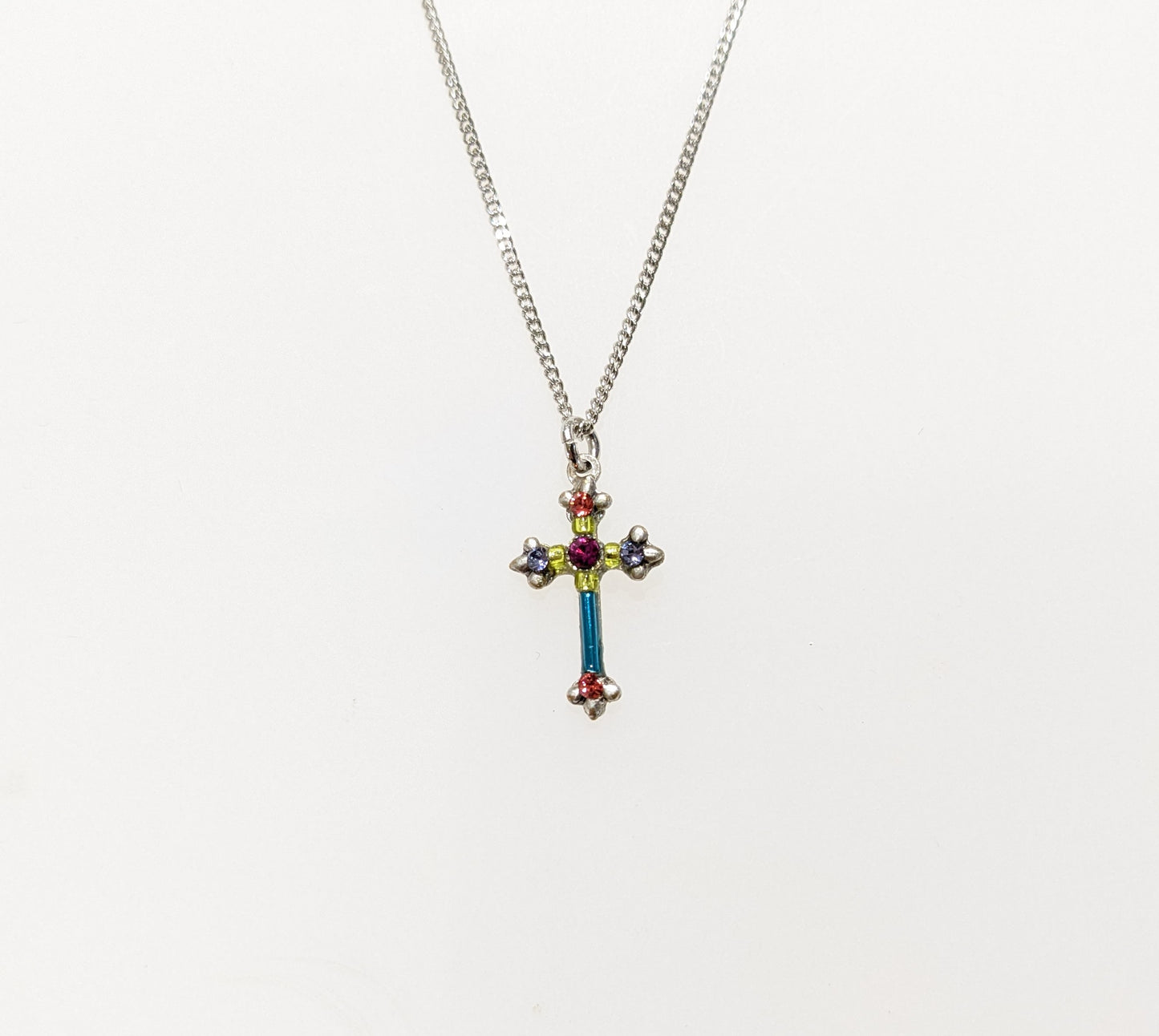 A multicolored cross necklace with a chain link and a lobster claw clasp.