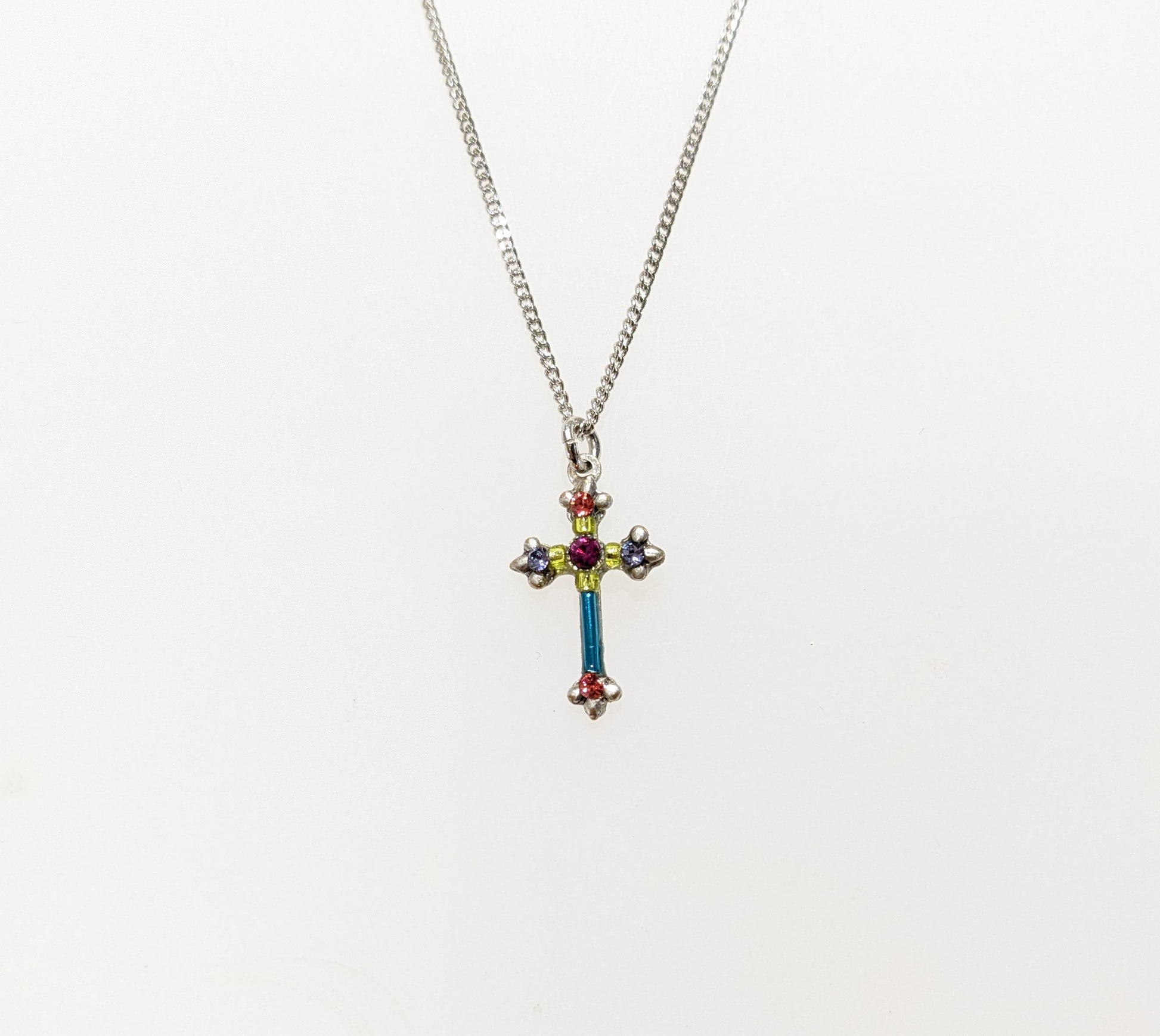 A multicolored cross necklace with a chain link and a lobster claw clasp.
