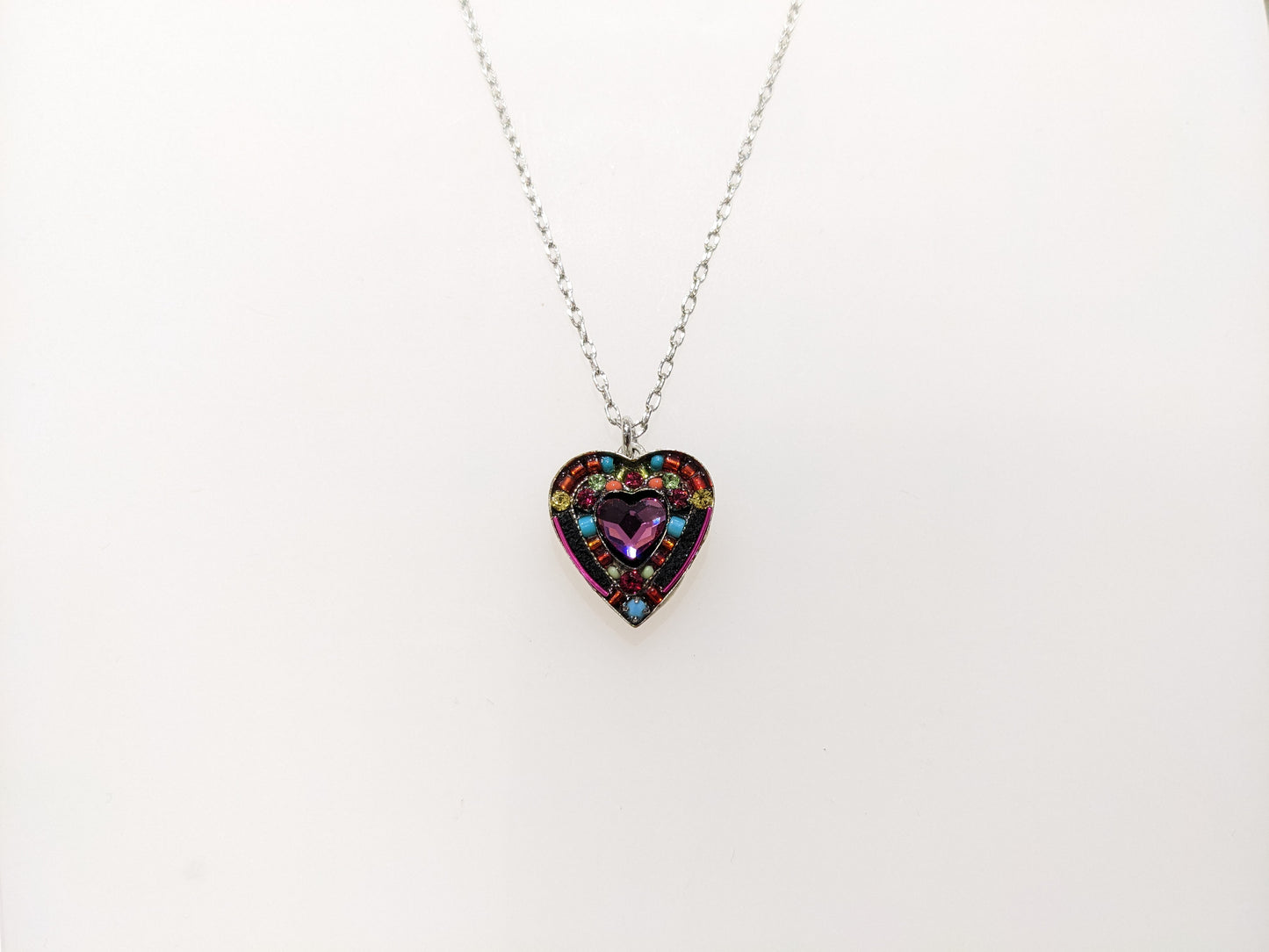 A multicolored heart-shaped Firefly Jewelry necklace with embellishments and a lobster claw clasp.