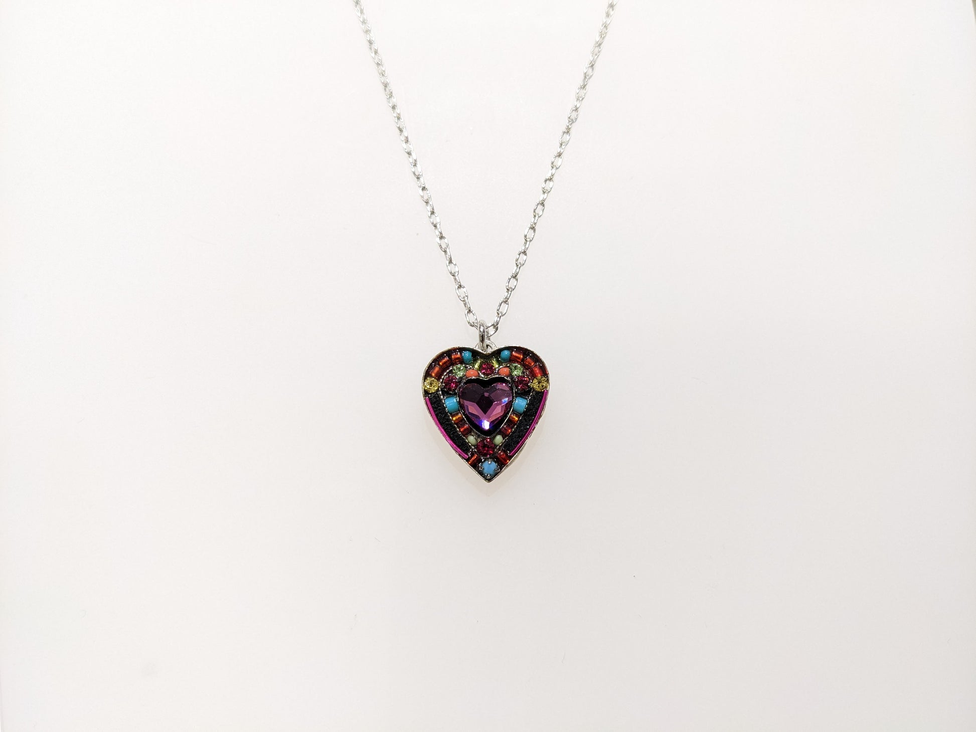 A multicolored heart-shaped Firefly Jewelry necklace with embellishments and a lobster claw clasp.