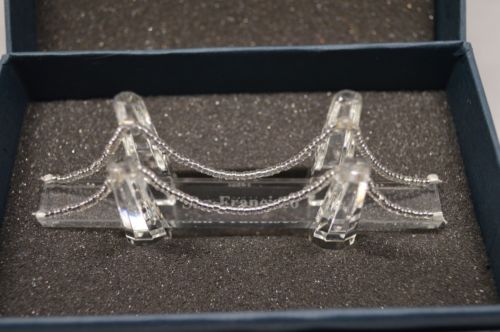A small crystal model of the Golden Gate Bridge, 4 inches wide, inside the box.