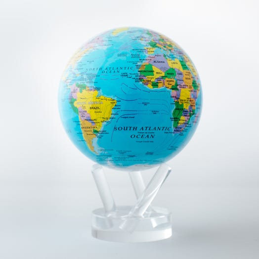 A map globe with blue oceans and multicolored countries, set on a clear stand, highlighting the South Atlantic Ocean.