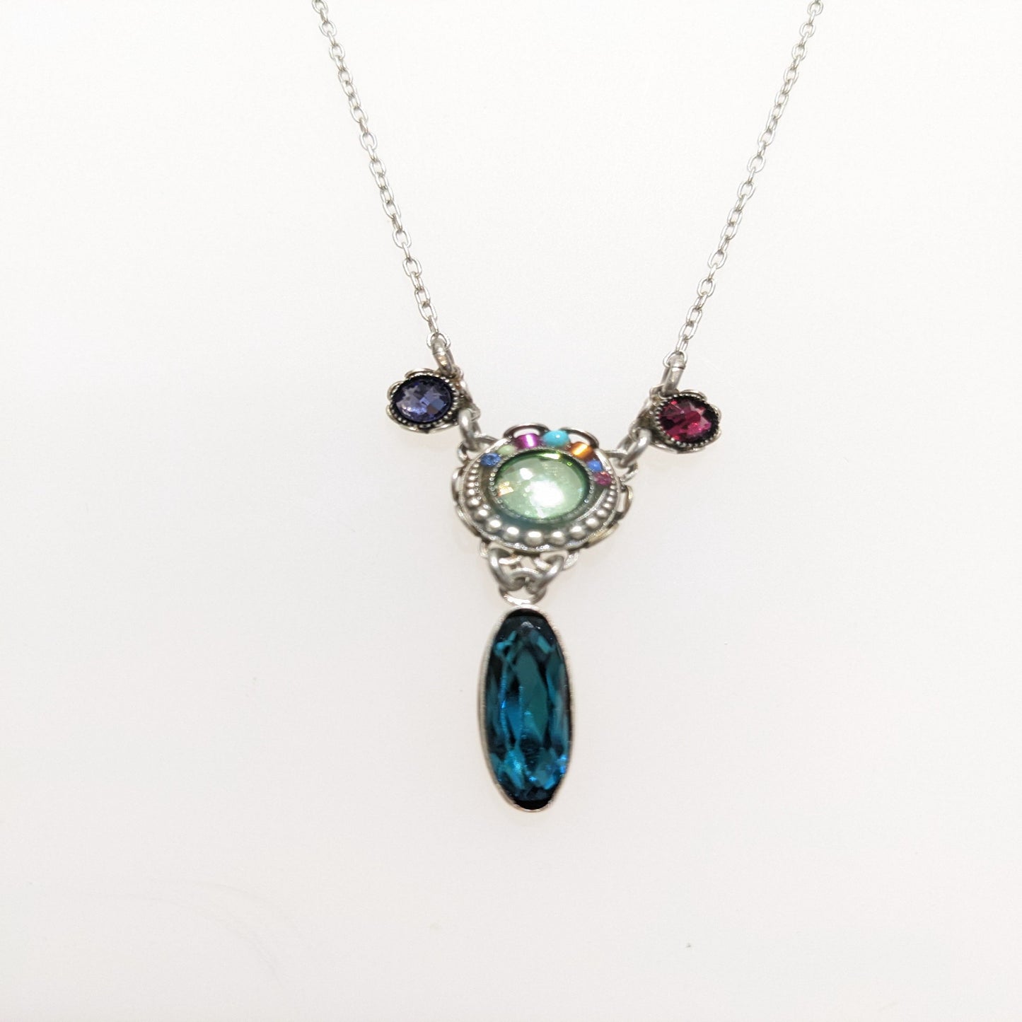 Necklace with a pendant featuring a blue teardrop and multicolored stones on a white background.