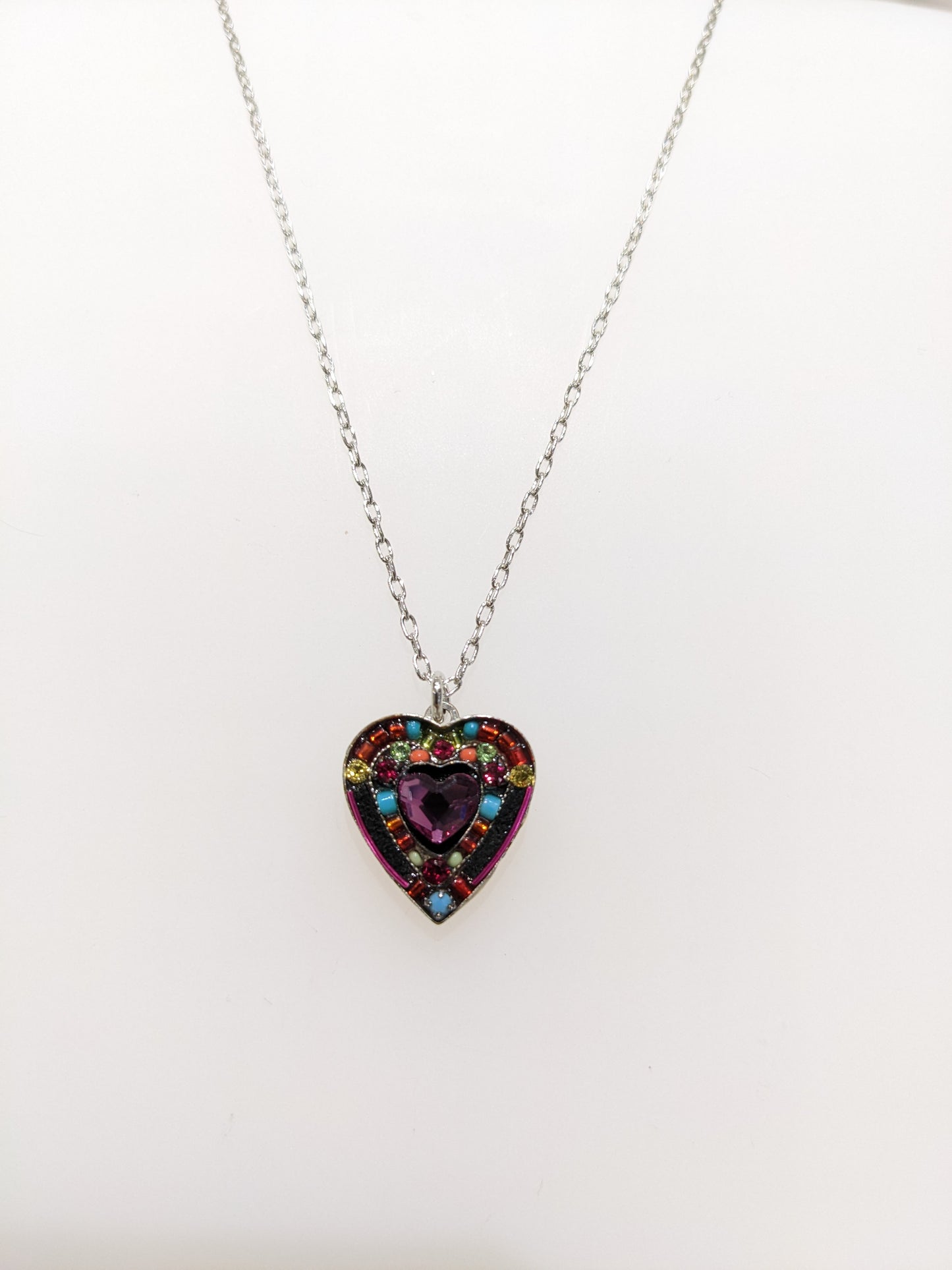 A multicolored heart-shaped Firefly Jewelry necklace on white background.
