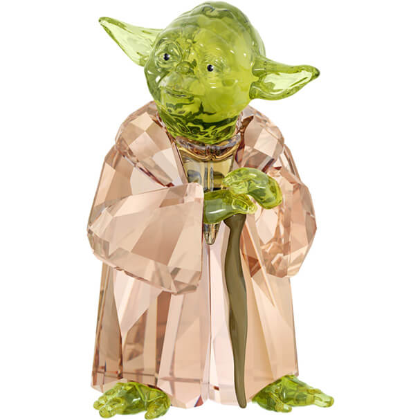 A crystal figurine of Master Yoda from Star Wars, crafted with green and brown hues and standing on a metal cane.