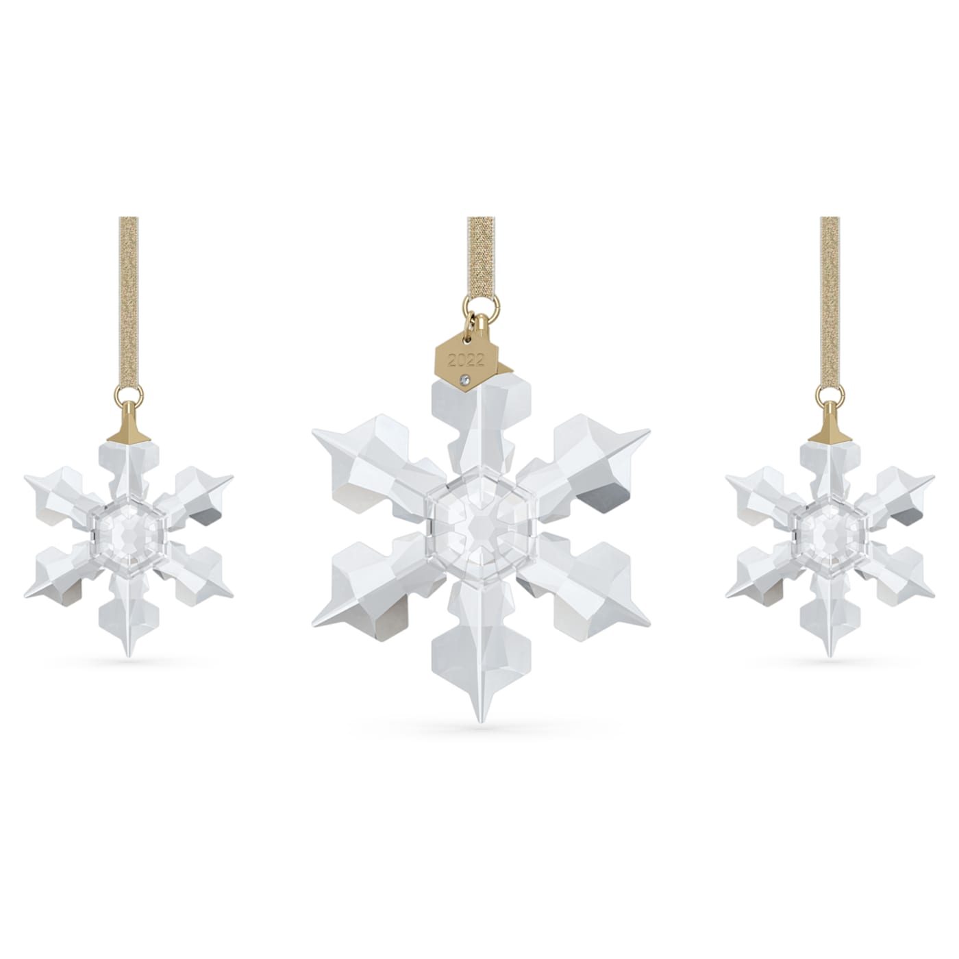 A set of three Swarovski crystal ornaments in a snowflake design, with the largest one featuring a golden lamé ribbon and a crystal-studded tag reading '2022'.