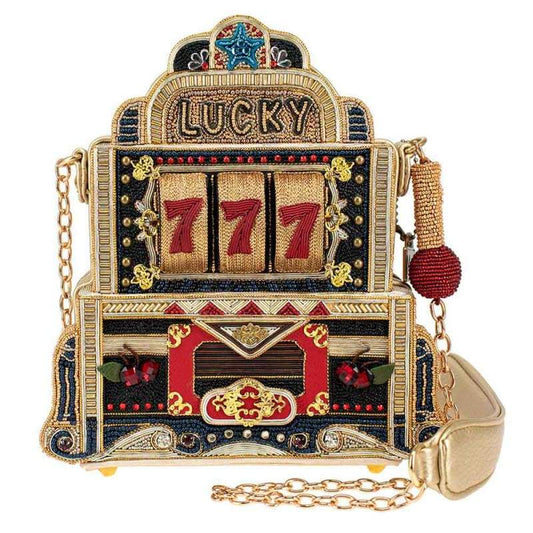 A crossbody handbag designed to look like a vintage slot machine with a 'Lucky 7' motif, featuring vibrant colors and a sequin finish.