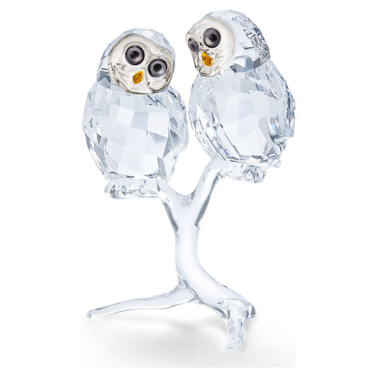 A crystal figurine of an owl couple with a loving expression, featuring clear crystal facets and perched on a small crystal tree.
