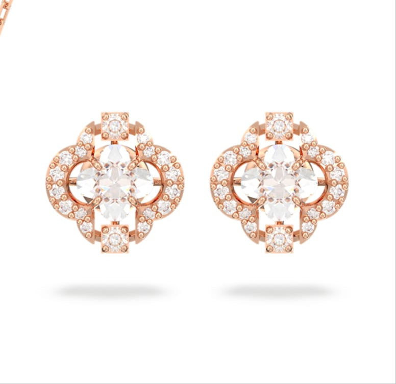 A set of rose gold-tone plated jewelry including a necklace and a pair of earrings, featuring clear crystals and a central clover-shaped stone.