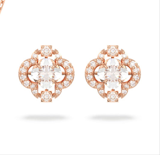 A set of rose gold-tone plated jewelry including a necklace and a pair of earrings, featuring clear crystals and a central clover-shaped stone.